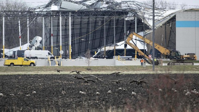 Tornado juga menghancurkan gudang dan fasilitas milik Amazon di Eadwardsville, Illinois, AS. Tampak fasilitas distribusi center tersebut rusak parah.