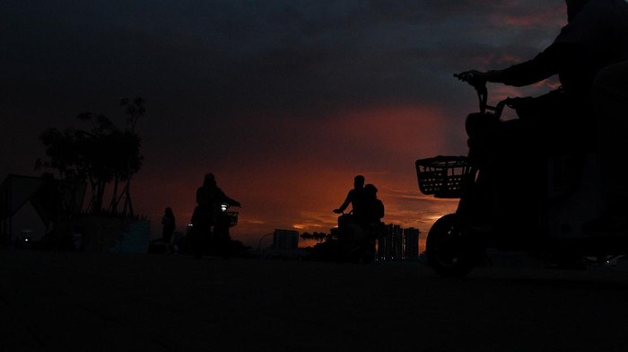 Warga menyaksikan matahari tenggelam saat mengunjungi kawasan Pantai Maju, Pantai Indah Kapuk (PIK), Kamal Muara, Jakarta, Sabtu (11/12/2021). Pantai Maju yang mempunyai fasilitas jalur jalan sehat dan sepeda santai (Jalasena) tersebut menjadi salah satu tujuan wisata di Ibu Kota. ANTARA FOTO/Wahyu Putro A/aww.