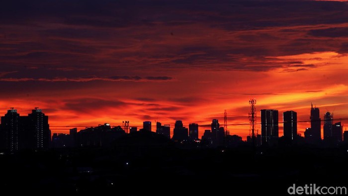 Suasana matahari tenggelam yang terlihat dari pemukiman padat Semper Barat, Jakarta Utara, Minggu (12/12). Matahari tenggelam pada hari ini terlihat berbeda.