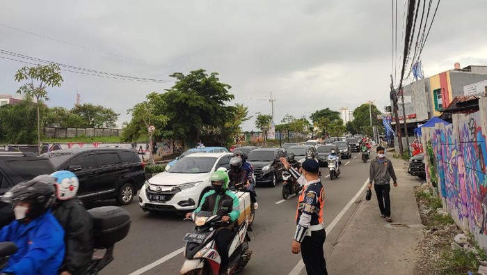 Sejumlah mobil pelat ganjil diputar balik di Jalan Juanda, Depok arah Margonda, Minggu (12/12/2021).