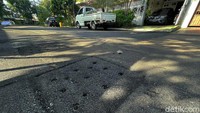 Sumur resapan di Jl Bona Vista, Perumahan Taman Bona Indah, Lebak Bulus, Jakarta Selatan, kini telah diaspal dan dilubangi untuk saluran air, Minggu (12/12/2021).