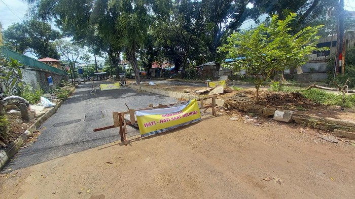 Truk terperosok sumur resapan.