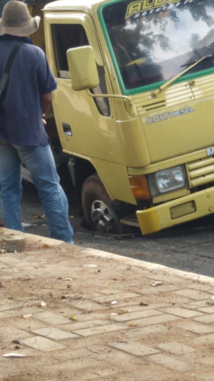Truk terperosok sumur resapan.