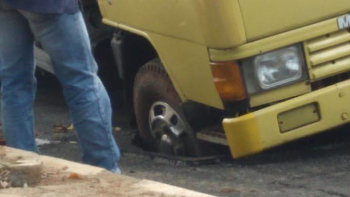 Truk terperosok sumur resapan.