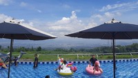 Tenda dan pengunjung di kolam renang.