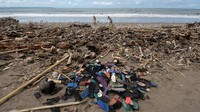 Wisatawan berjalan di dekat tumpukan sampah yang berserakan di sepanjang Pantai Berawa, Kuta Utara, Badung, Bali, Minggu (12/12/2021).