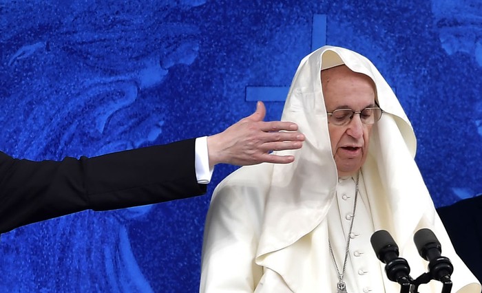 A gust of wind blows Pope Francis's mantle as walks to the airplane before his departure from Eleftherios Venizelos International Airport in Athens, Greece, Monday, Dec. 6, 2021. Francis' five-day trip to Cyprus and Greece has been dominated by the migrant issue and Francis' call for European countries to stop building walls, stoking fears and shutting out 