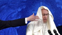 Salah seorang imam berusaha mengembalikan jubah Paus Fransiskus yang tertiup angin saat memberikan misa suci di Irlandia (26/8/2018). (Photo: Charles McQuillan/Getty Images)