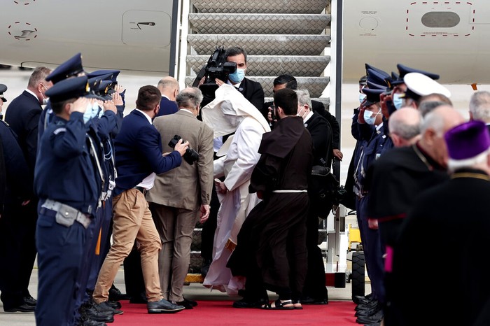 Greece Pope A gust of wind blows Pope Francis's mantle as walks to the airplane before his departure from Eleftherios Venizelos International Airport in Athens, Greece, Monday, Dec. 6, 2021. Francis' five-day trip to Cyprus and Greece has been dominated by the migrant issue and Francis' call for European countries to stop building walls, stoking fears and shutting out