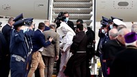 Angin kencang di kawasan bandara membuat jubah paus berkibar ketika ia hendak masuk ke pesawat di Bandara Athena, Yunani (6/12/2021). Paus Fransiskus mulai memimpin gereja Katholik Roma sejak 13 Maret 2013 lalu. (AP Photo/Yorgos Karahalis)