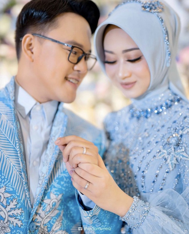 Wanita yang berusia 28 tahun ini memilih hijab segi empat yang dililit rapi ke belakang, dilengkapi dengan beads biru di atas hijab pada sesi foto prewedding. Detail beads pada hijab cocok digunakan untuk acara resmi, menambah kesan feminin dan cantik. Hemas mengenakan dres bertabur payet warna biru muda rancangan Delmora Attire. Foto: Dok.Instagram @hemasnura.