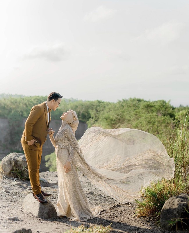 Danang dan Hemas pun beberapa kali mengadakan sesi foto prewedding dengan berbeda tema. Kali ini keduanya memilih sesi foto dengan pemandangan keindahan alam Gunung Merapi. Hermas menggunakan head piece cantik dan gaun serba nude bertabur payet. Foto: Dok.Instagram @hemasnura.