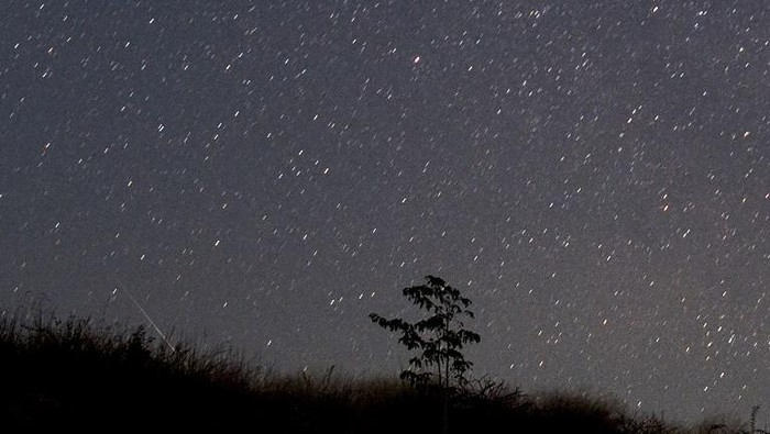 This photo taken late December 14, 2018 with a long time exposure shows a meteor streaking through the night sky over Myanmar during the Geminid meteor shower seen from Wundwin township near Mandalay city. (Photo by Ye Aung THU / AFP)