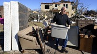 Beberapa hari usai tornado menerjang kawasan Kentucky, sejumlah warga kembali ke rumah mereka yang rusak berat untuk mengumpulkan barang-barang yang masih dapat diselamatkan. AP Photo/Mark Humphrey.