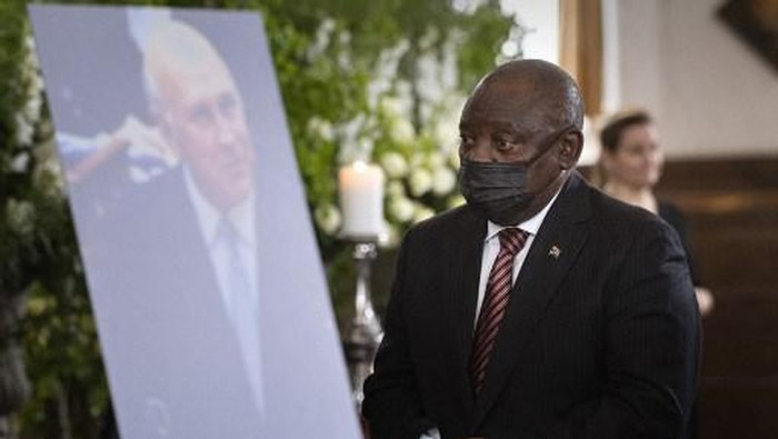 South African President Cyril Ramaphosa walks past a photo of former South African President FW de Klerk at de Klerks state memorial service at the Groote Kerk church in Cape Town on December 12, 2021. (Photo by RODGER BOSCH / AFP)