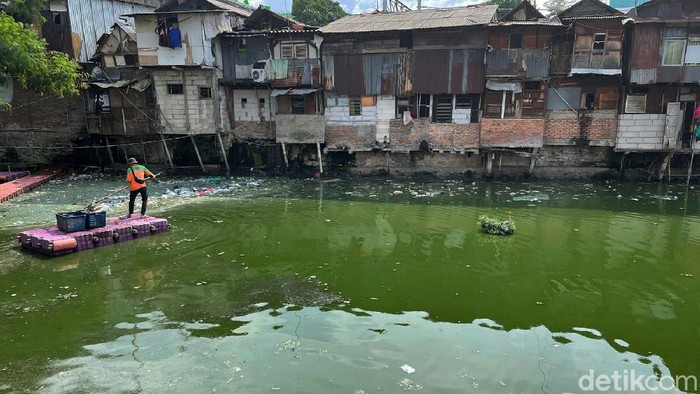 Petugas membersihkan sampah yang mengambang di Kali Cideng, Jakarta, Senin (13/12/2021). Banyaknya sampah yang dibuang membuat kali ini kotor dan berbau.