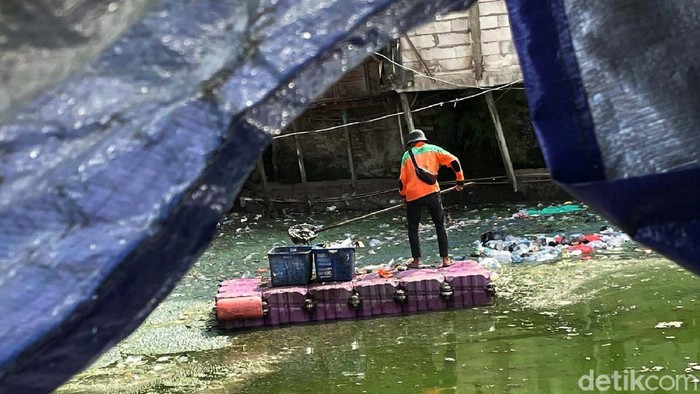 Petugas membersihkan sampah yang mengambang di Kali Cideng, Jakarta, Senin (13/12/2021). Banyaknya sampah yang dibuang membuat kali ini kotor dan berbau.