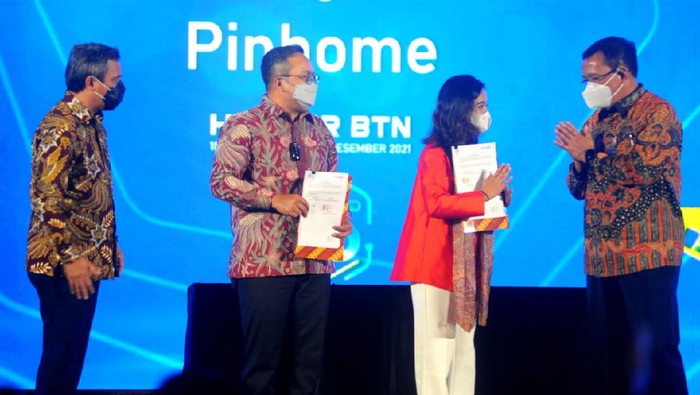 Direktur Utama PT Bank Tabungan Negara (Persero) Tbk, Haru Koesmahargyo (kanan) dan Wakil Direktur Bank BTN Nixon LP Napitupulu (kiri) menyaksikan Direktur Operation IT &Digital Banking BTN, Andi Nirwoto (kedua dari kiri) dan CEO-Founder Pinhome Dayu Dara Permata (kedua dari kanan)  menandatangani Nota Kesepahaman tentang Sinergi Bisnis di sela sela HUT KPR ke 45 di Jakarta, Jumat (10/12).  Sinergi dengan Pinhome bertujuan mendukung Bank BTN dalam mempersiapkan digital mortgage ecosystem dan meningkatkan penyaluran KPR Bank BTN, layanan operasional, memperluas akses pengajuan KPR online, pemasaran dan menambah kanal penjualan properti bagi developer yang bermitra.