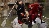 Dengan menggunakan perahu karet para petugas penyelamat mengevakuasi warga yang terjebak banjir.