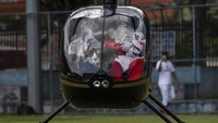 Tak naik kereta kuda, Sinterklas ini justru menaiki helikopter saat hendak menemui anak-anak di Villa Kennedy favela, Brasil.