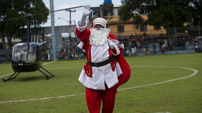 Sinterklas mendatangi anak-anak di tengah perayaan menyambut Natal di Rio de Janeiro, Brasil. Tak naik kereta kuda, Sinterklas ini tiba dengan helikopter.