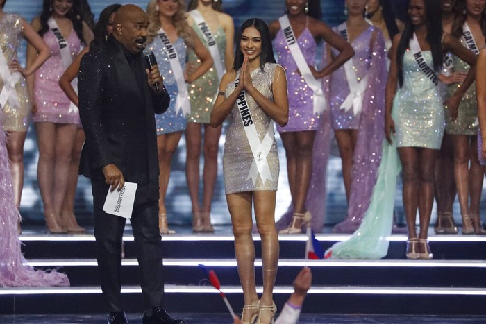 Wakil Filipina di Miss Universe 2021 Host Steve Harvey, left, speaks with The Philippines Beatrice Luigi Gomez as she advances to the semifinals of the 70th Miss Universe pageant, Monday, Dec. 13, 2021, in Eilat, Israel. (AP Photo/Ariel Schalit)