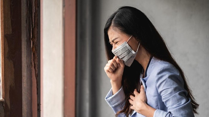COVID-19 Pandemic Coronavirus, Asian woman wearing a mask, have a symptoms coughing and fever