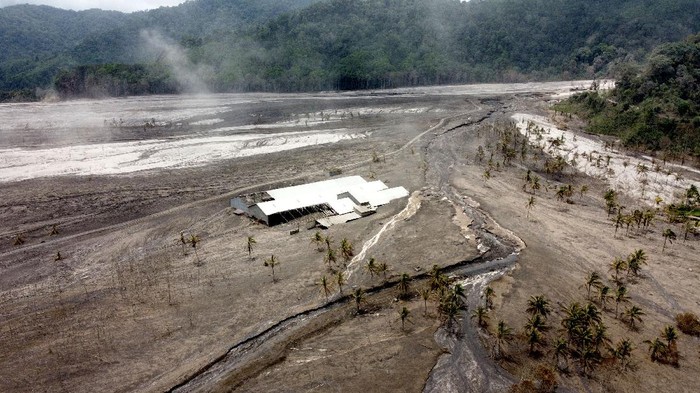 Abu Vulkanik Semeru Sapu Bersih Kampung Kamar Panjang Foto udara kondisi kampung terdampak lahar hujan Gunung Semeru di Kamar Kajang, Candipuro, Lumajang, Jawa Timur, Selasa (14/12/2021). Puluhan rumah di kawasan tersebut tertutup material pasir bercampur batu hingga ketinggian sekitar 2,5 meter yang menyebabkan warganya mengungsi. ANTARA FOTO/Budi Candra Setya/foc.