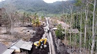 Foto udara pembersihan jalan yang tertutup lahar hujan Gunung Semeru di Kamar Kajang, Candipuro, Lumajang, Jawa Timur, Selasa (14/12/2021).   