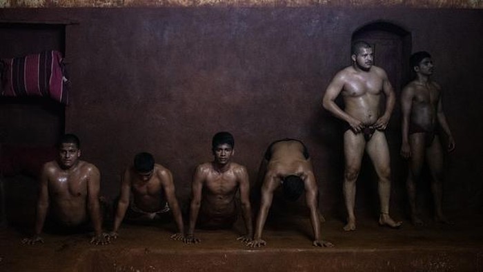 KOLHAPUR, INDIA - DECEMBER 11: Traditional 'kushti' wrestlers gather to make breakfast after a morning training session at the Shri Shahu Vijayi Gangavesh Talim on December 11, 2021 in Kolhapur, India. A national lockdown and restrictions introduced in the wake of the coronavirus pandemic has kept traditional wrestling gyms in Kolhapur closed for much of the past two years. (Photo by Rebecca Conway/Getty Images)