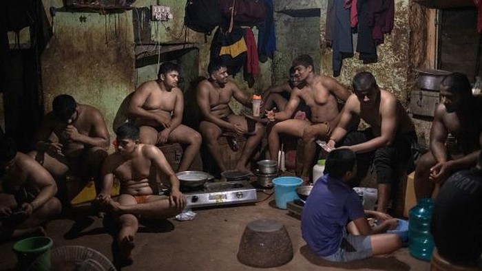 KOLHAPUR, INDIA - DECEMBER 11: Traditional 'kushti' wrestlers gather to make breakfast after a morning training session at the Shri Shahu Vijayi Gangavesh Talim on December 11, 2021 in Kolhapur, India. A national lockdown and restrictions introduced in the wake of the coronavirus pandemic has kept traditional wrestling gyms in Kolhapur closed for much of the past two years. (Photo by Rebecca Conway/Getty Images)