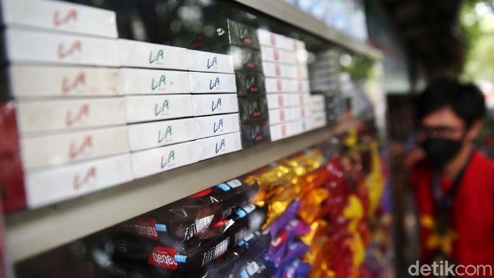 Pemilik warung kelontong menata rokok di Jakarta, Selasa (14/12/2021). Cukai hasil tembakau (CHT) atau cukai rokok tahun depan ditetapkan naik oleh pemerintah. Rata-rata kenaikannya sebesar 12%. Menteri Keuangan Sri Mulyani Indrawati menjelaskan kenaikan ini sudah disetujui oleh Presiden dan Menteri Koordinator Bidang Perekonomian.