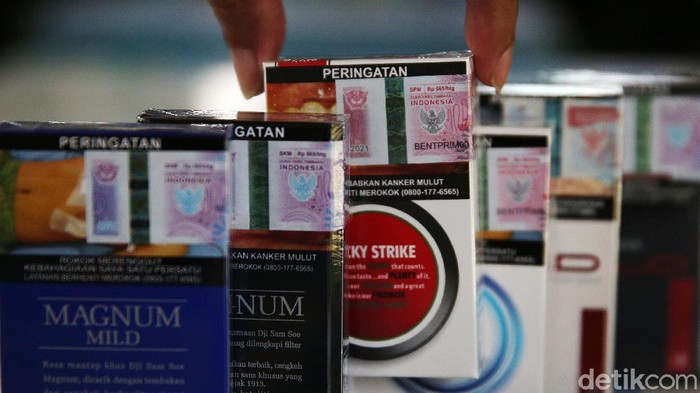 Cukai Rokok Naik 12% Tahun Depan Pemilik warung kelontong menata rokok di Jakarta, Selasa (14/12/2021). Cukai hasil tembakau (CHT) atau cukai rokok tahun depan ditetapkan naik oleh pemerintah. Rata-rata kenaikannya sebesar 12%. Menteri Keuangan Sri Mulyani Indrawati menjelaskan kenaikan ini sudah disetujui oleh Presiden dan Menteri Koordinator Bidang Perekonomian.