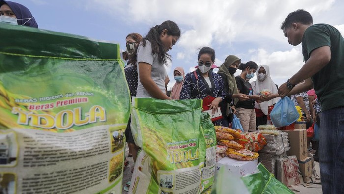 Warga bertransaksi jual beli kebutuhan pokok pada gelaran pasar murah di Batam, Kepulauan Riau, Selasa (14/12/2021). Pasar murah yang digelar Dinas Perindustrian dan Perdagangan (Disperindag) Kota Batam tersebut untuk membantu memenuhi kebutuhan masyarakat serta sebagai upaya menjaga stabilitas harga kebutuhan pokok jelang Natal 2021 dan Tahun Baru 2022. ANTARA FOTO/Teguh Prihatna/hp.
