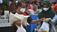 Warga membawa sejumlah kebutuhan pokok usai berbelanja di pasar murah. ANTARA FOTO/Mohamad Hamzah