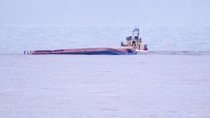 Divers work on the capsized Danish cargo ship Karin Hoej, right, after it collided with British cargo vessel Scot Carrier in the Baltic Sea, between Ystad and Bornholm, Sweden, Monday, Dec. 13, 2021. Two cargo ships collided in the Baltic Sea off southern Sweden and at least two people were reported missing Monday. One of the vessels capsized and will be towed to a Swedish port, authorities said. The maritime administration said it received a pre-dawn alarm that two cargo ships had collided south of Ystad in Sweden, close to the Danish island of Bornholm. The authority identified the ships as the Danish-flagged Karin Hoej and a British ship, the Scot Carrier. The Danish ship capsized fully and was floating upside down. (Johan Nilsson/TT via AP)