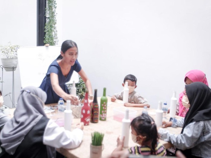Migi Rihasalay melukis di botol.