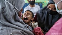 Bahkan ada yang harus dipegang oleh beberapa orang saat divaksinasi.