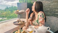 Sambil duduk di balkon melihat pemandangan laut, Syifa memilih minum secangkir teh sambil ngemil beberapa potong kue manis. Momen ini diambil ketika Syifa liburan ke Bali.  Foto: Instagram @syifahadjureal