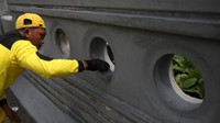 Petugas pasukan kuning melakukan pengecetan jembatan 66 Kuningan, Jakarta, Rabu (15/12/2021).