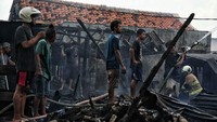 Petugas melakukan proses pendinginan di kawasan permukiman yang kebakaran, Kramat Pulo Gundul, Senen, Jakarta Pusat, Rabu (15/12/2021).