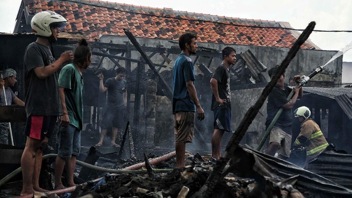 Permukiman Padat di Kramat Pulo Gundul Porak Poranda Usai Dilalap Api Petugas melakukan proses pendinginan di kawasan permukiman yang kebakaran, Kramat Pulo Gundul, Senen, Jakarta Pusat, Rabu (15/12/2021).