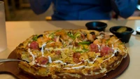Gerai pizza bernama Mr. Pizza di Korea Selatan memiliki menu yang unik. Hadir menu kombinasi gurih dan manis. Selain topping udang, pizza di sini juga dibuat dari adonan yang dicampurkan biskuit. Foto: SCMP