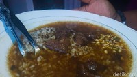 Seporsi nasi rawon di sini porsinya cukup banyak. Rawon langsung dituangkan ke atas nasi dengan kuah yang membanjiri permukaan piring. Foto: detikFood/Yenny Mustika Sari