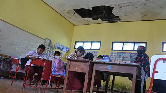 Tak Kunjung Diperbaiki, Siswa di Situbondo Terpaksa Belajar di Kelas Rusak Siswa SDN 01 Alasbayur belajar di ruang kelas yang rusak di Desa Alasbayur, Mlandingan, Situbondo, Jawa Timur, Rabu (15/12/2021). Siswa SDN 01 Alasbayur tersebut terpaksa belajar di ruang kelas yang rusak meski pihak sekolah sudah melaporkan sekolah rusak itu sejak tahun 2019 dan belum ada perbaikan dari Pemerintah Kabupaten Situbondo. ANTARA FOTO/Seno/rwa.