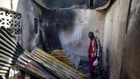 Seorang warga melihat atap seng yang runtuh di dalam sebuah rumah yang dirusak oleh truk bensin yang terbalik dan meledak di Cap-Haitien, Haiti.