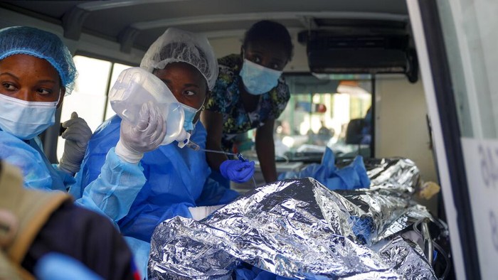 Truk BBM Meledak Tewaskan 62 Orang di Haiti Petugas pemadam kebakaran berdiri di samping sisa-sisa truk yang membawa bensin setelah terbalik dan meledak di Cap-Hatien, Haiti, Selasa, 14 Desember 2021. Ledakan itu menghanguskan mobil dan rumah, menewaskan lebih dari 50 orang dan melukai puluhan lainnya. dari yang lain. (Foto AP/Joseph Odelyn)