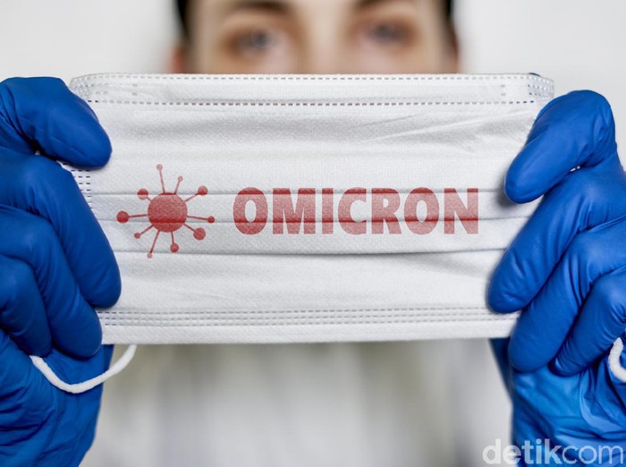 Female doctor holds a face mask with - Omicron variant text on it. Covid-19 new variant - Omicron. Omicron variant of coronavirus. SARS-CoV-2 variant of concern