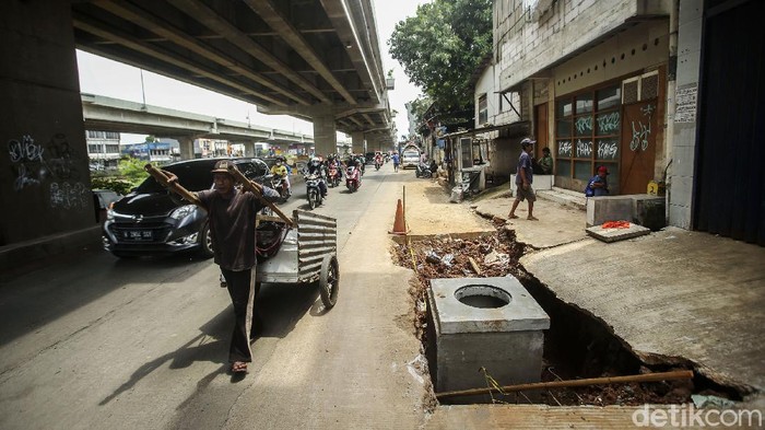 Sejumlah kendaraan melintas di jalan raya Kalimalang, Bekasi, Kamis (16/12/2021). Lubang-lubang yang berasal dari proyek nampak tak tertutup.