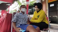 Azam Raya (6), salah satu siswa TK juga antusias mendapatkan vaksin. Duduk di kursi tempat vaksin, bocah laki-laki itu menggenggam erat biskuit di tangan kanannya sembarai memejamkan mata. Di sampingnya ada petugas kepolisian yang berusaha menenangkan. 